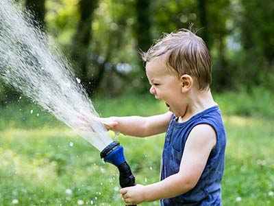 toddler boy playing with sprayer